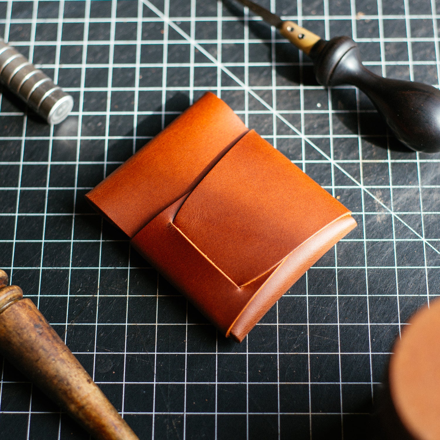 Back of the Brown Cash Emerson Wallet on a worktable with tools nearly